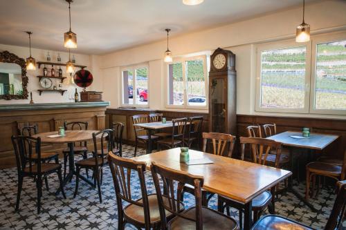 a restaurant with tables and chairs and a clock at Auberge de Rivaz in Rivaz