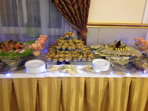 a table with a buffet of food on it at Hotel Colosseum in Olecko