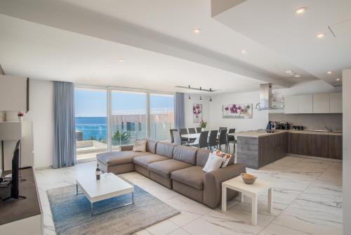 a living room with a couch and a kitchen at The Sea-Bank Villa Apartments in Marsaskala