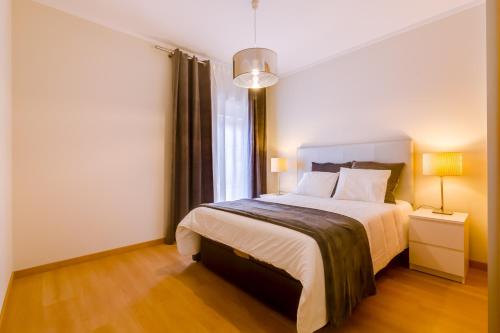 a bedroom with a bed and a window at Village Marina Olhão in Olhão