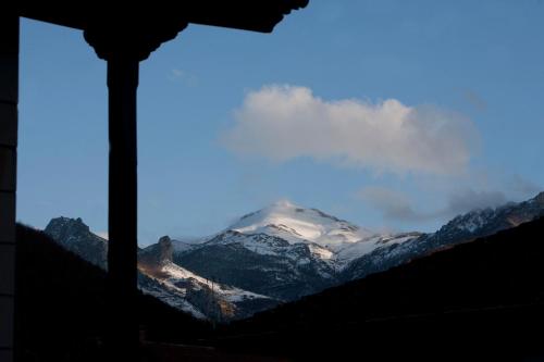 a view of a snow covered mountain from a window at Posada Rural Bistruey in Potes