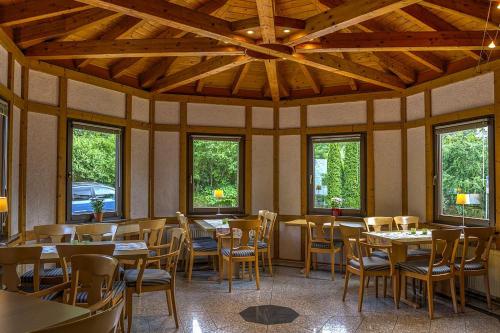 a dining room with tables and chairs and windows at Irreler Mühle Ferienwohnungen und Ferienhäuser in Irrel