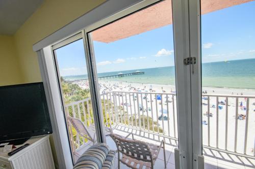 a room with a balcony with a view of the beach at Edison Beach House in Fort Myers Beach