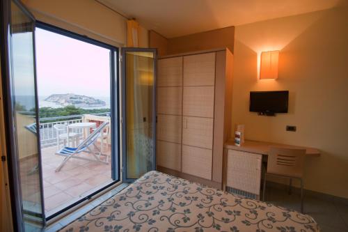 a bedroom with a bed and a view of a balcony at Hotel Gabbiano in San Domino