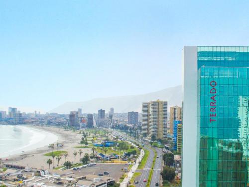 a view of a city with a building and a beach at Hotel Terrado Cavancha in Iquique