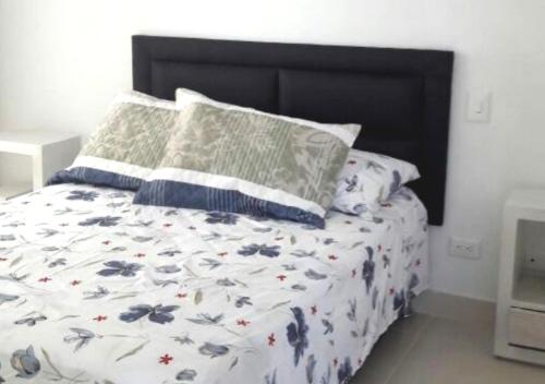 1 dormitorio con 1 cama con sábanas y almohadas florales en Casa Quinta familiar piscina privada Girardot, en Girardot