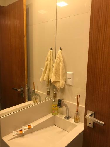 ein Badezimmer mit Waschbecken und großem Spiegel in der Unterkunft Praia do Forte Apt. in Praia do Forte