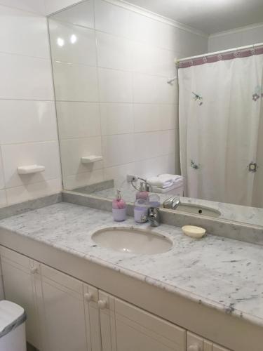 encimera con lavabo y espejo en Departamento 501, en Pucón