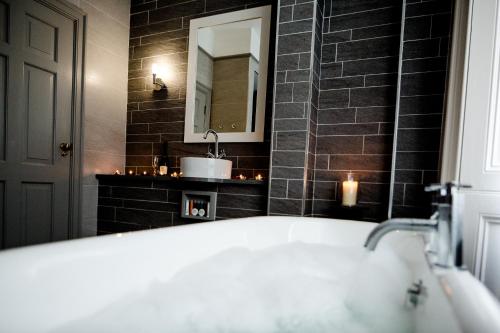 a bathroom with a bath tub and a mirror at Gretna Hall Hotel in Gretna Green