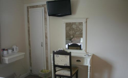 a room with a desk and a television on the wall at Riverside B&B in Cushendall