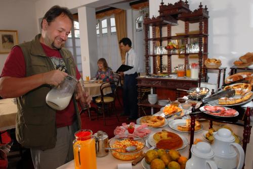 a man is pouring milk into a buffet of food at El Hotel de Su Merced in Sucre