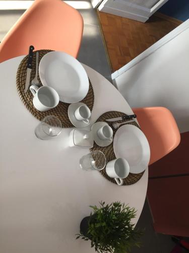 una mesa blanca con tazas y platillos. en Casa Ettolina al Campus Einaudi, en Turín
