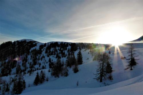 a snow covered mountain with the sun shining on it at Appartement Spath in Kaprun