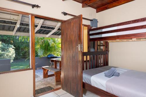 a bedroom with a bed and a large window at Manzini Chalets in St Lucia