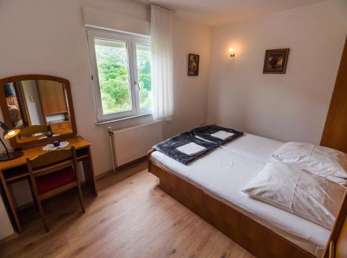 ein Schlafzimmer mit einem Bett, einem Schreibtisch und einem Spiegel in der Unterkunft 689 Banjol in Rab