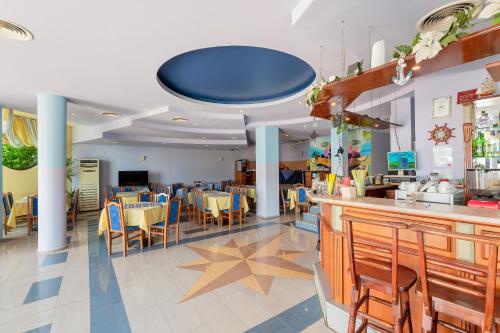 a restaurant with a bar and tables and chairs at Family Hotel Evridika in Nesebar