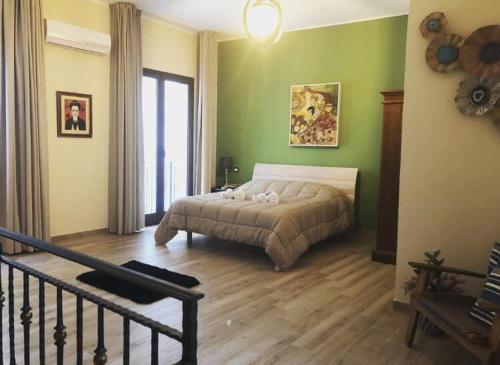 a bedroom with a bed in a green wall at Isolabella in Mazara del Vallo