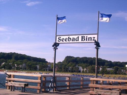 a sign on a pier with two flags at Pension Sanddorn mit Café Carlssons in Binz