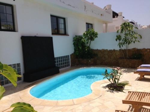 una piscina frente a una casa en Villa Beach Club, en Corralejo