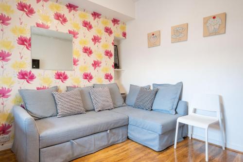 Fraser Apartment في أبردين: غرفة معيشة مع أريكة زرقاء ومرآة