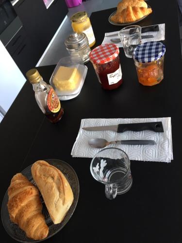 una mesa negra con un plato de pan y condimentos en La chambre rose, en Mâcon