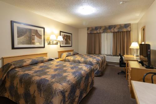 a hotel room with two beds and a desk at Best Maple Inn - Drayton Valley in Drayton Valley
