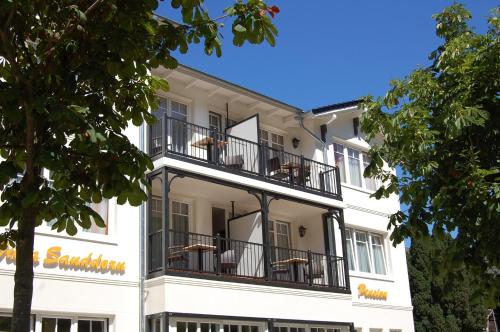 a large white building with balconies on it at Pension Sanddorn mit Café Carlssons in Binz