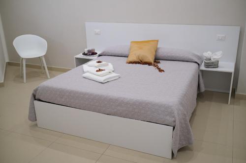 a bedroom with a bed with towels on it at Hoa Suites in Aversa