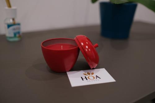 a red coffee cup sitting on a table with a note at Hoa Suites in Aversa