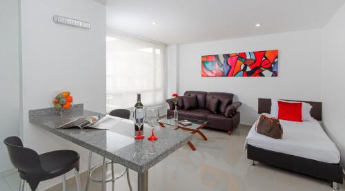 a living room with a table and a bed at 122 Plaza Apartahotel in Bogotá