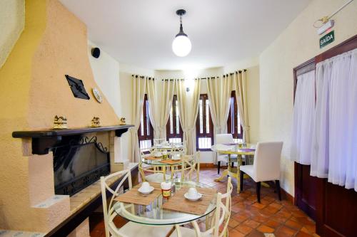 a living room with a table and chairs and a fireplace at Pousada Estalagem de Brotas in Brotas