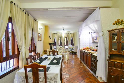 a dining room with a table and a kitchen at Pousada Estalagem de Brotas in Brotas