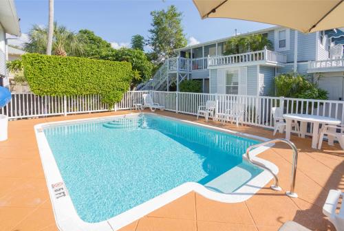 a swimming pool with a table and chairs and a house at Meranova Guest Inn in Dunedin