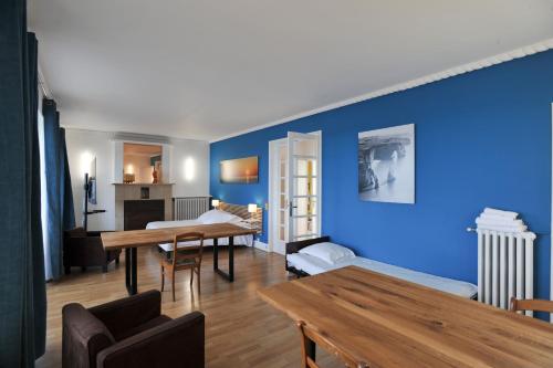 a living room with blue walls and a table at Gîte de la Plage in Étretat