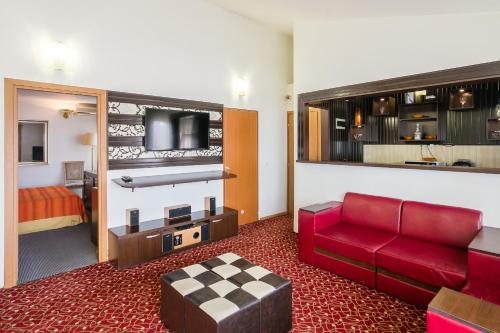 a hotel room with a red couch and a bed at Casa Sofia in Bucharest