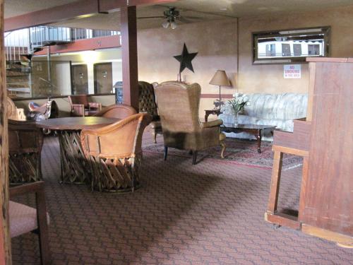 a living room with chairs and a table and a couch at Dodge House Hotel in Dodge City