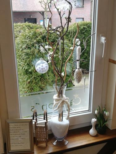 a vase sitting on a window sill with a branch in it at Pension Sanddorn mit Café Carlssons in Binz