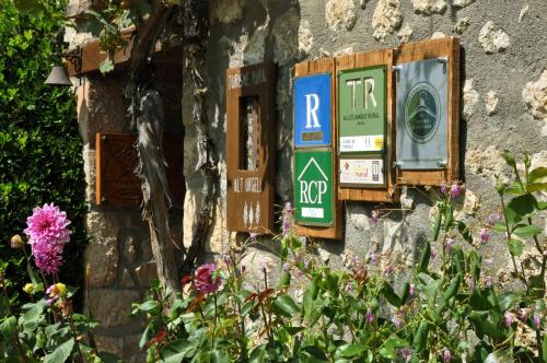 a stone wall with signs and flowers on it at Casa Rural Molí de Fòrnols in Fornols