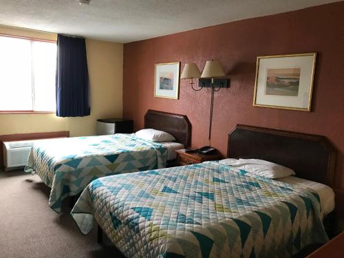 a hotel room with two beds and a window at Economy Inn in Fort Wayne