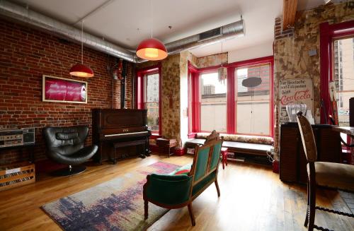 a living room with a piano and a brick wall at Hostel Fish in Denver