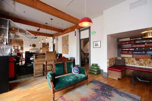 a living room with a green couch and a kitchen at Hostel Fish in Denver