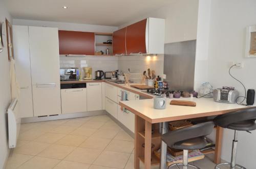 une cuisine avec des armoires blanches et une table en bois dans l'établissement Côte d'Azur Villa Amicalement Hôte, à Coursegoules