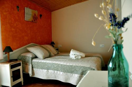 a bedroom with a bed and a vase of flowers at Casa Rural Molí de Fòrnols in Fornols