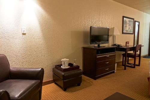 a hotel room with a couch and a tv and a table at Gold Circle Inn in Lloydminster