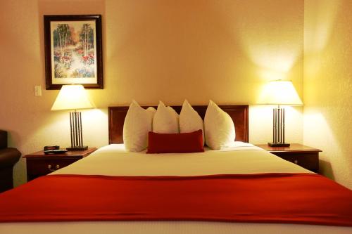 a hotel room with a large bed with two lamps at Gold Circle Inn in Lloydminster