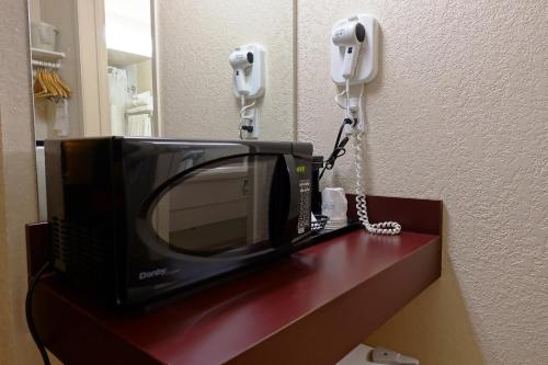 a television and a phone on a counter with at Gold Circle Inn in Lloydminster