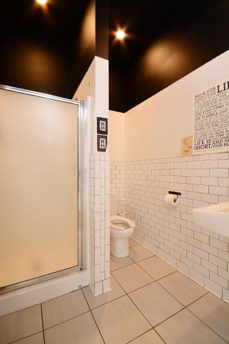 a bathroom with a shower and a toilet and a sink at Hostel Fish in Denver