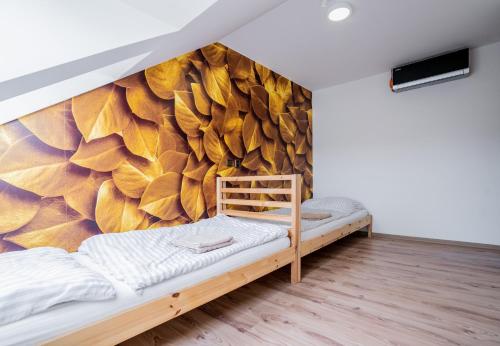 a bedroom with a large mural of leaves at Aroma Gold in Dolní Bousov