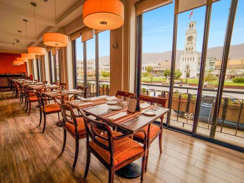 a restaurant with tables and chairs and a clock tower at Terrado Arturo Prat Iquique in Iquique