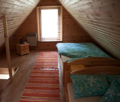 a attic room with two bunk beds and a window at Kimalase Metsamaja in Misso